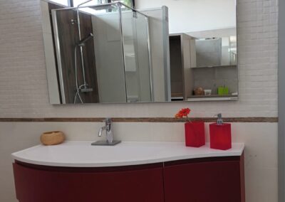 Composizione FORM J curvo cm. 125 laccato opaco ROSSO SCURO, top in mineralsolid bianco opaco con vasca integrata e bordo salvagoccia, specchio ECO cm 120 x h 90 con illuminazione led integrata superiore e interruttore touch
